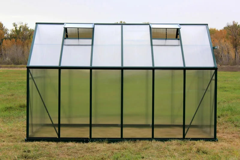 Greenhouse structure with transparent panels on a grassy field